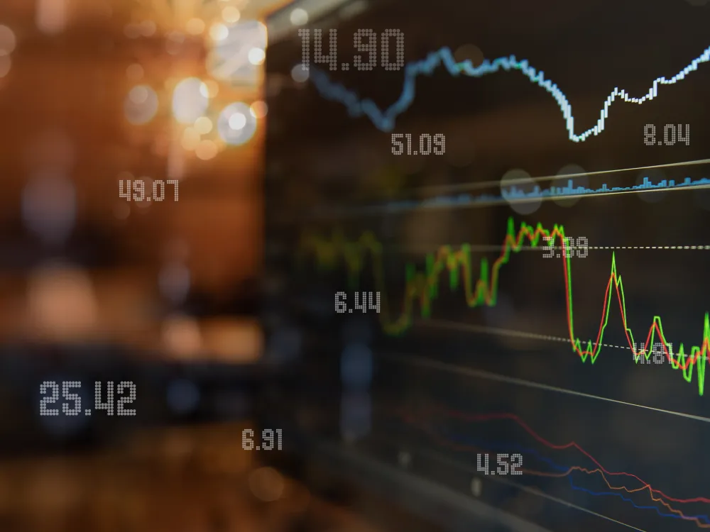 Close-up view of a digital stock market chart showing fluctuating lines and numerical values on a screen, representing financial data and market trends.