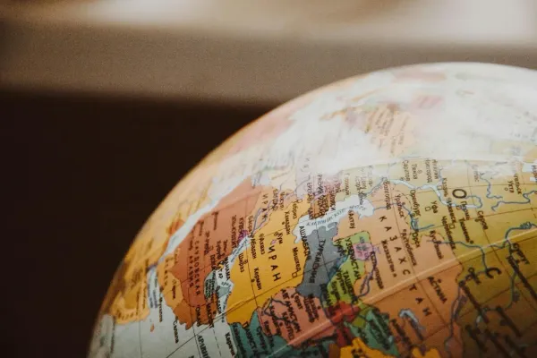 Close-up of a globe focusing on Eurasia, showcasing colorful countries and geographical features against a blurred background.