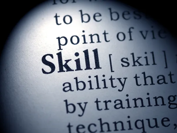 Close-up of the word "Skill" in a dictionary, highlighting its definition as an ability developed through training and technique.